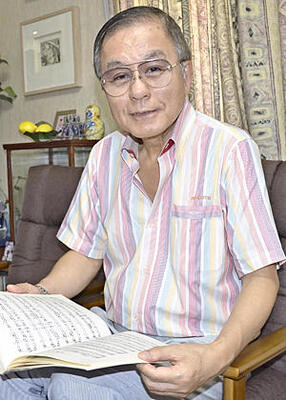 古関作品の楽譜を手にしながら父の思い出を語る長男正裕さん＝東京都大田区