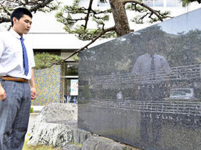 青春歌の歌碑を見つめ「福商生として誇りある歌」と話す土屋さん