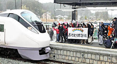 ９年ぶりの運行再開に伴い、双葉駅に入る特急「ひたち」。ホームでは「おかえり常磐線」と書かれた横断幕を持つ人たちが列車を出迎えた＝２０２０年３月１４日