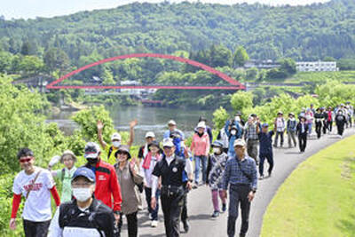 只見川周辺の緑豊かなコースを歩く参加者＝柳津町