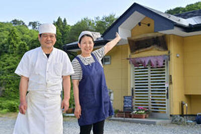 平田村の中華飯店萬ん里の前に立つ石井正彦さん（左）と妻節子さん。多彩な中華料理が村民や国道４９号を行き交う人から人気を集める（吉田義広撮影）