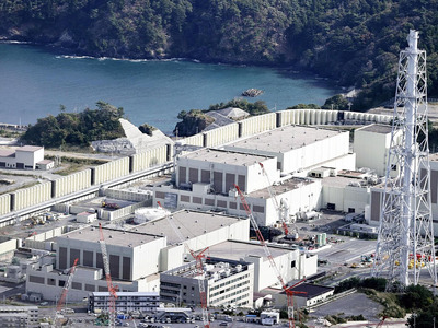 東北電力女川原発２号機（奥）＝２４日（共同通信社機から）