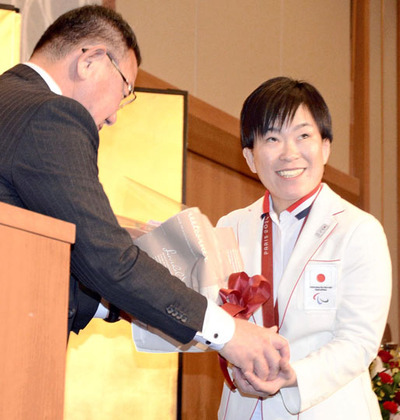 松本さん（左）から花束を受ける半谷