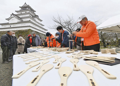 一枚ずつ丁寧に進められる「飯べら」の焼き印押し作業＝９日午前、会津若松市・鶴ケ城