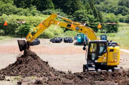 　特定帰還居住区域で始まった除染作業で、農地の表土を削り取る作業員＝２０日午前、福島県浪江町