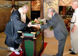 　高野山の金剛峯寺で行われた夏野菜の奉納式で、「高野山麓精進野菜」を受け取る今川泰伸宗務総長（左）＝９日午後、和歌山県高野町