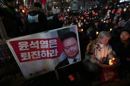 　４日、韓国の尹錫悦大統領の辞任を求め、ろうそくをともす人々＝ソウル（ＡＰ＝共同）